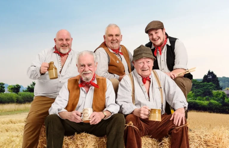 The Wurzels posing for a photo on a hay bale.